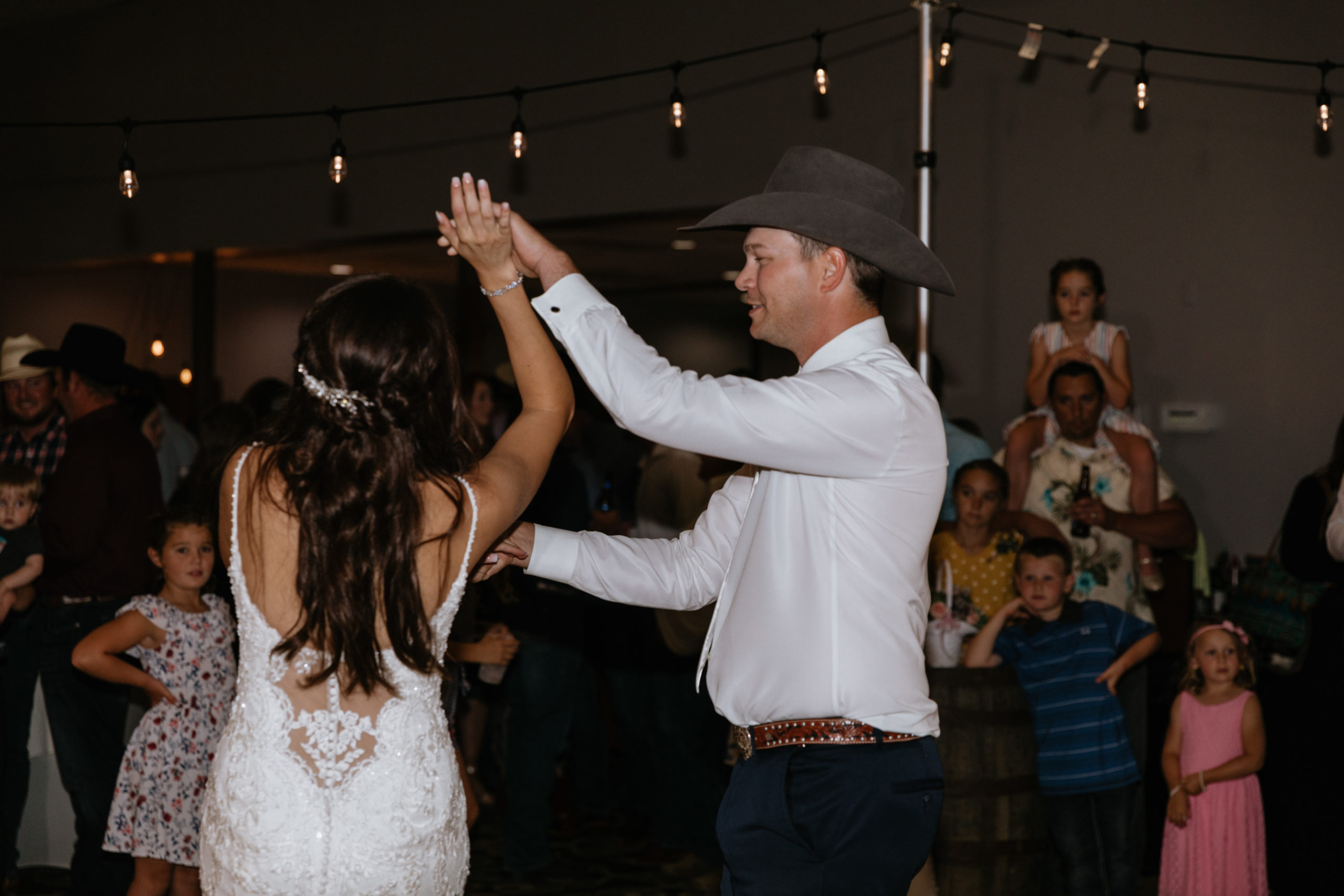 Heidi and Wyatt dance under string lights.