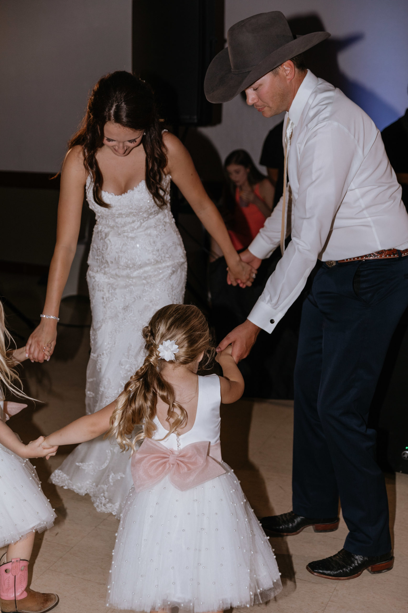 Heidi and Wyatt dance with children on the dance floor.