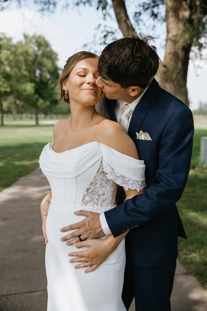 groom kissing the bride on the cheek