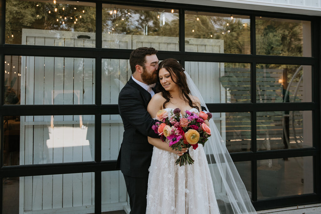 Groom kissing the bride on the forehead