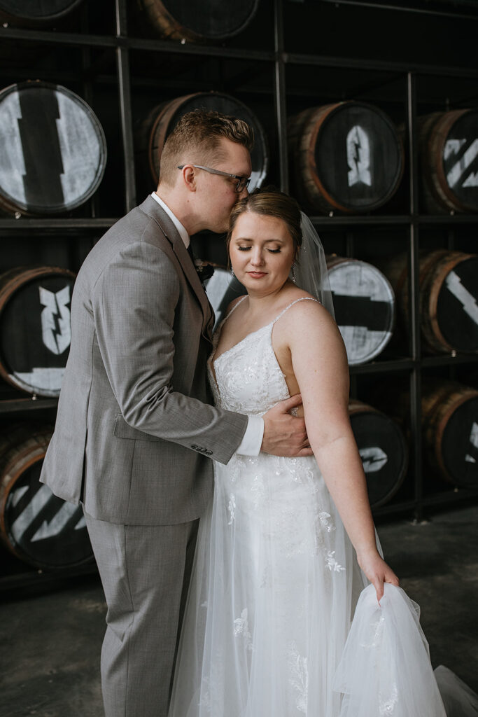 Groom kissing the bride on the forehead