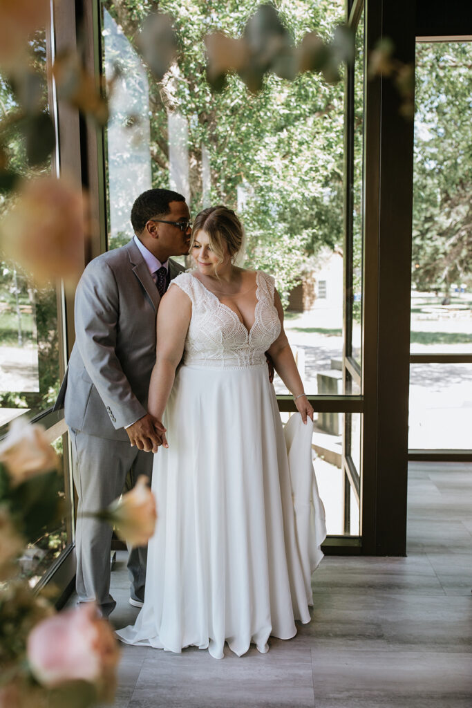groom kissing the bride on the cheek