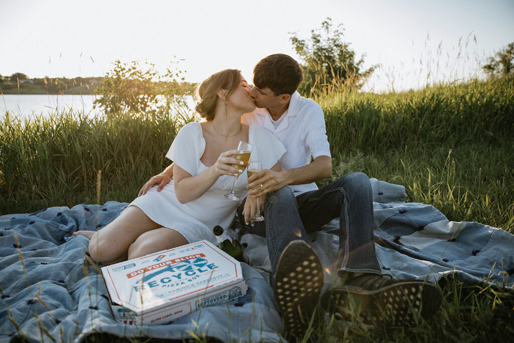 cute couple celebrating their engagement with champagne and pizza