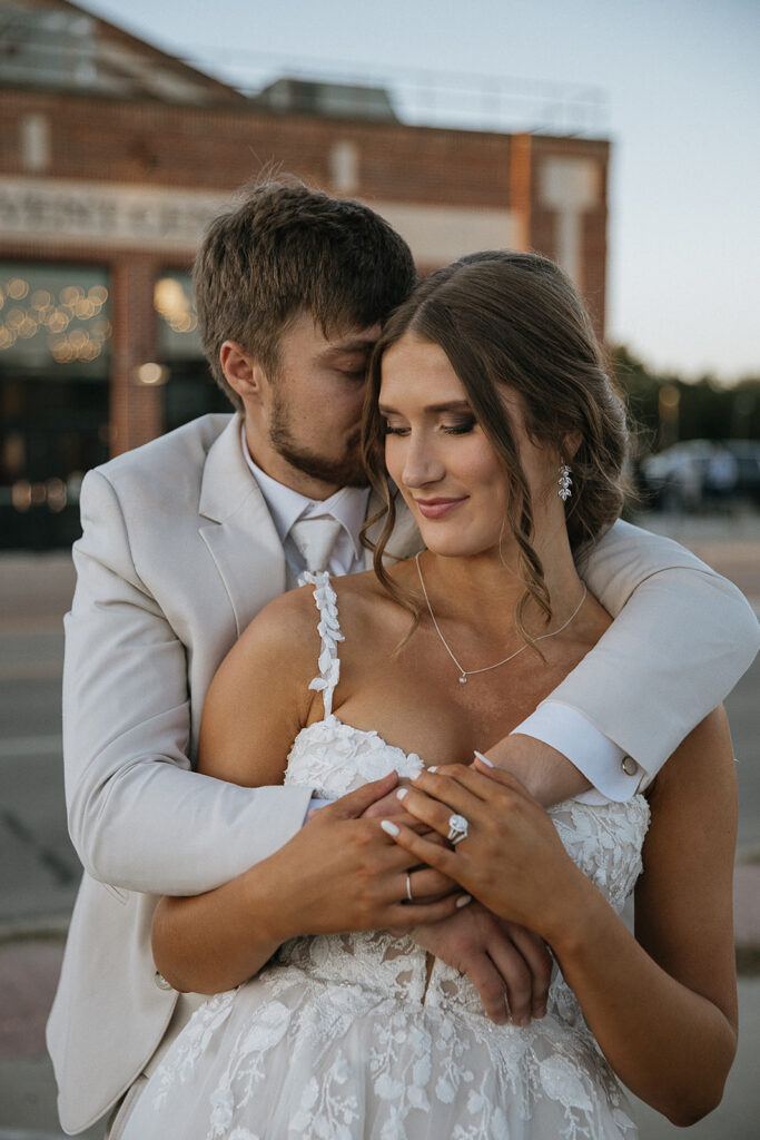 portrait of the groom kissing the bride on the cheek