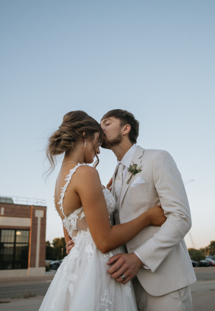 groom kissing the bride on the forehead