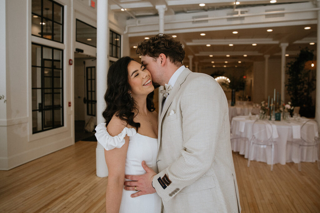 groom kissing the bride on the cheek