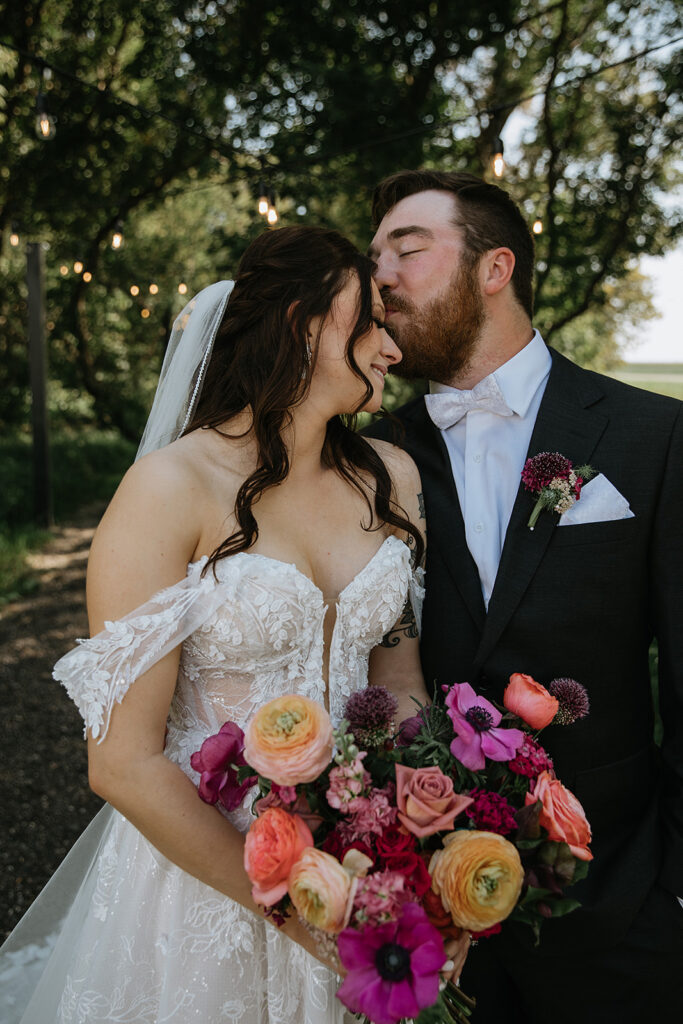 groom kissing the bride on the forehead