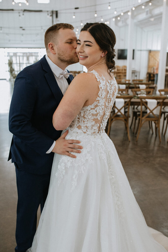 groom kissing the bride on the cheek