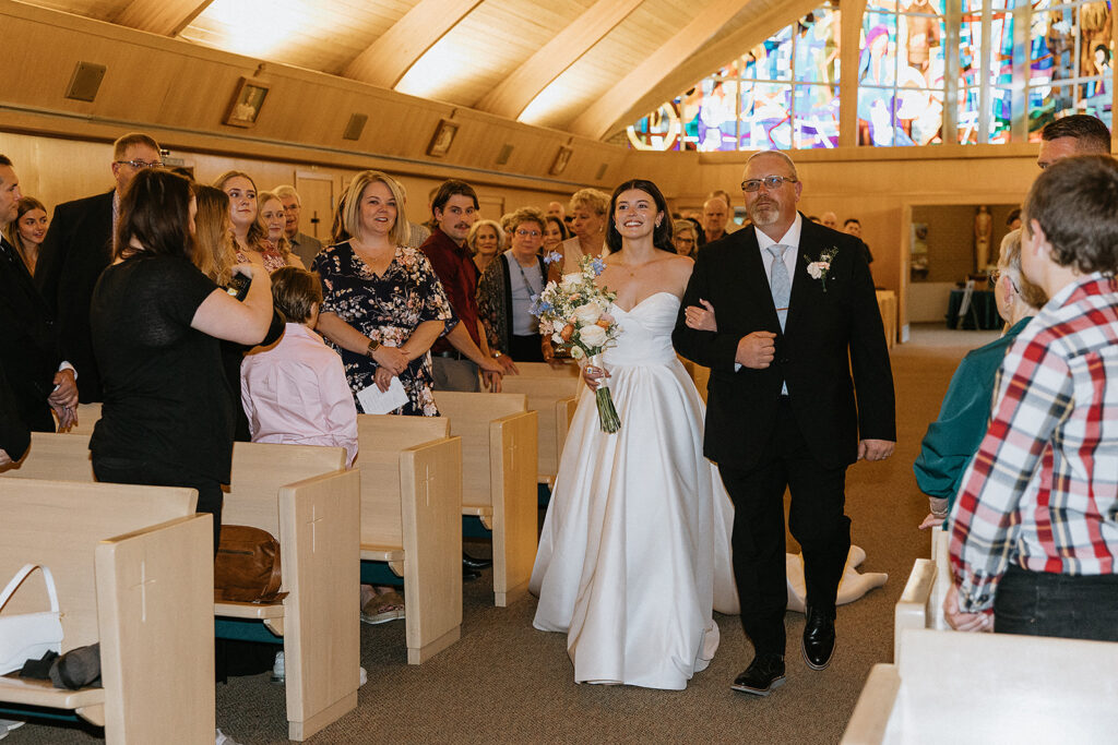 Beautiful picture of the bride walking down the aisle with her dad