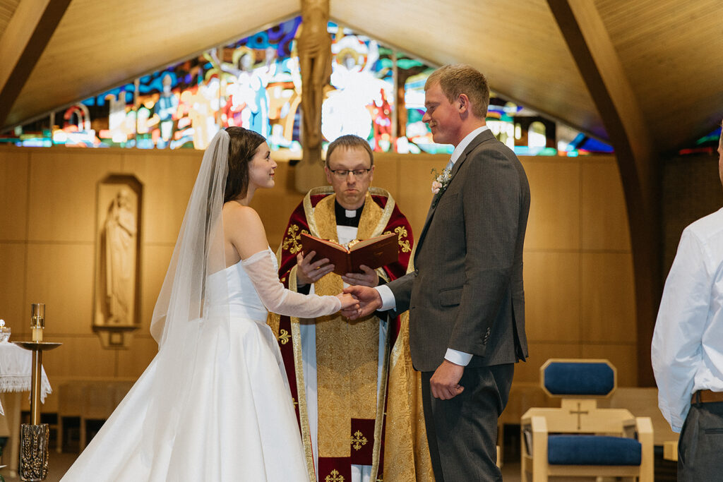 Beautiful picture of the bride and groom holding hands during their wedding ceremony