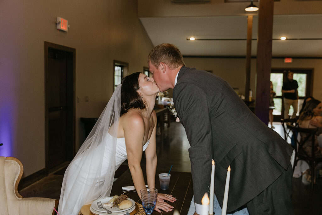 Cute picture of the newly married couple kissing at their wedding reception