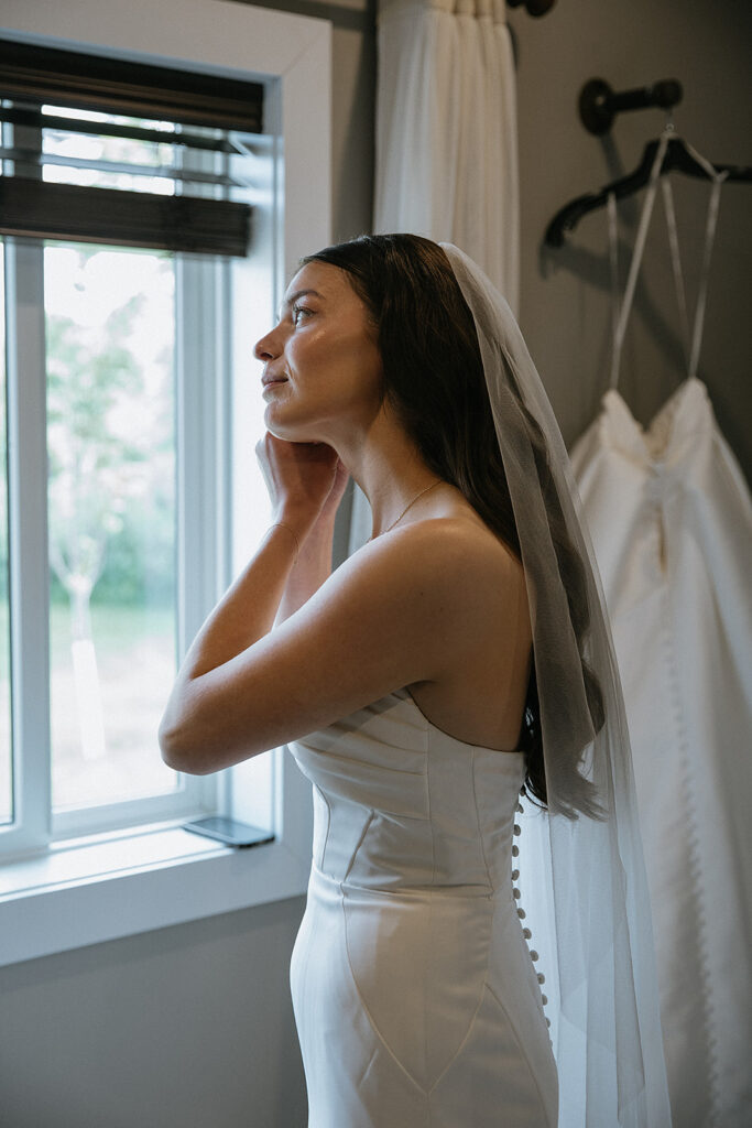 Bride putting on her jewelry before the ceremony