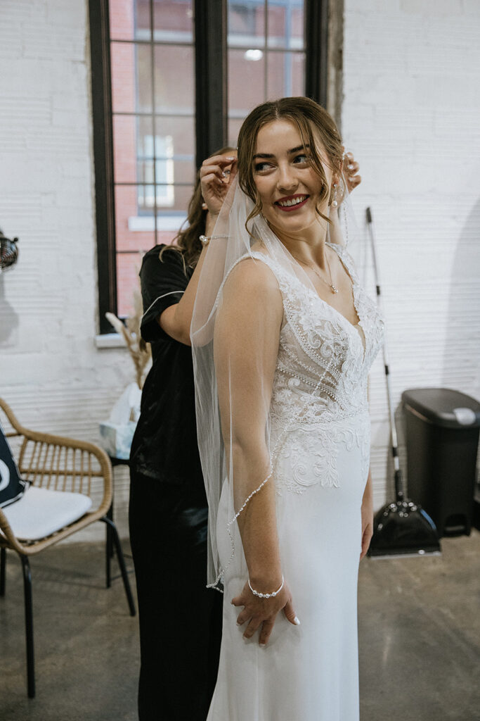 Bridesmaid helping the bride with her veil