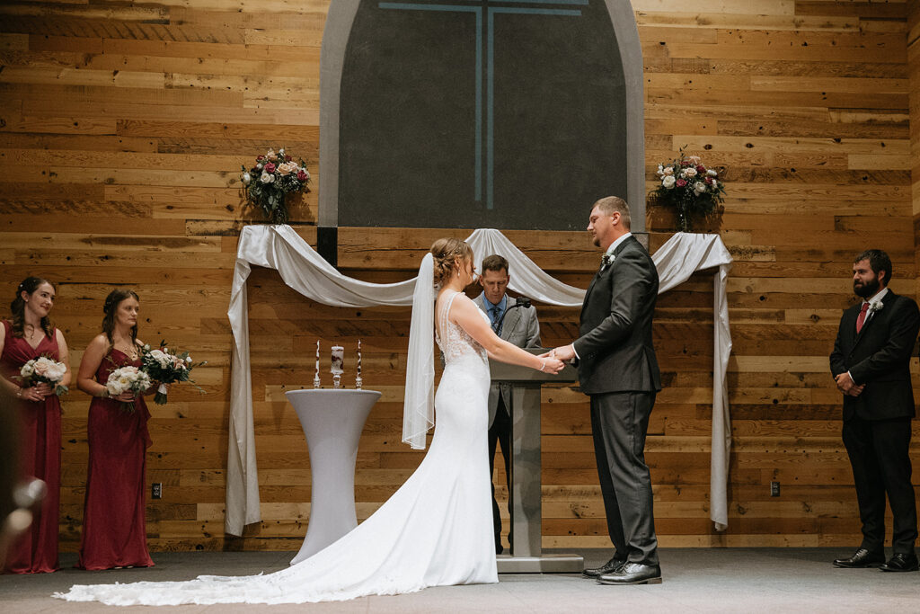 Cute picture of the bride and groom, holding hands during their wedding ceremony