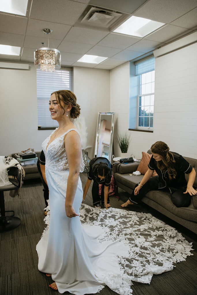 Bridesmaids helping the bride with her wedding dress