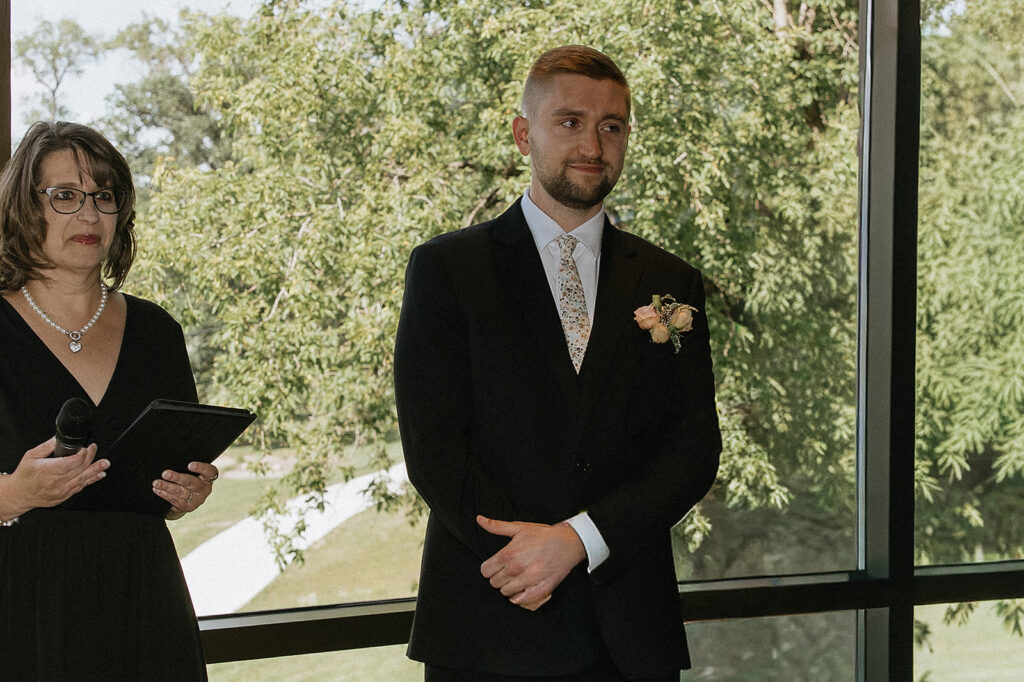 groom watching the bride walk down the aisle