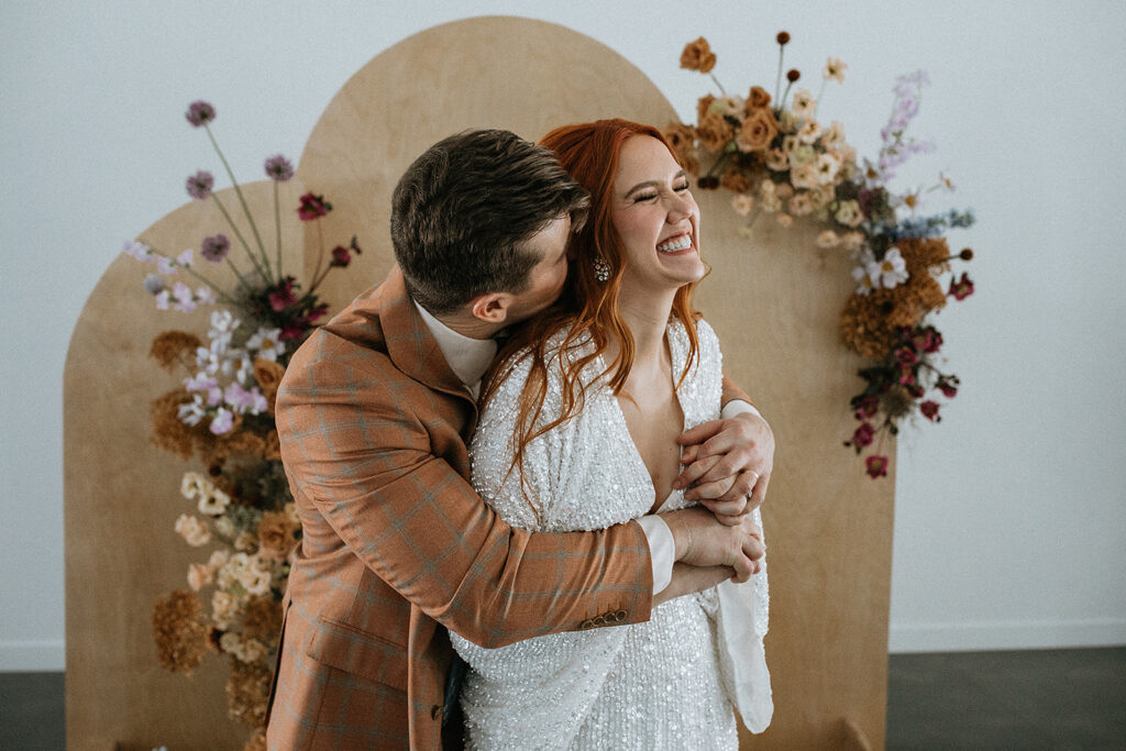 cute picture of the groom kissing the bride on the cheek