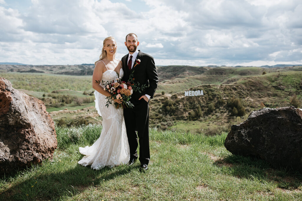 newlyweds smiling at the camera during their photoshoot