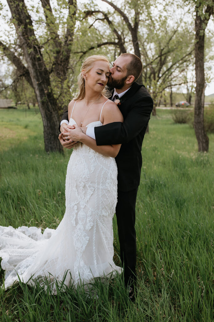 groom kissing the bride on the cheek