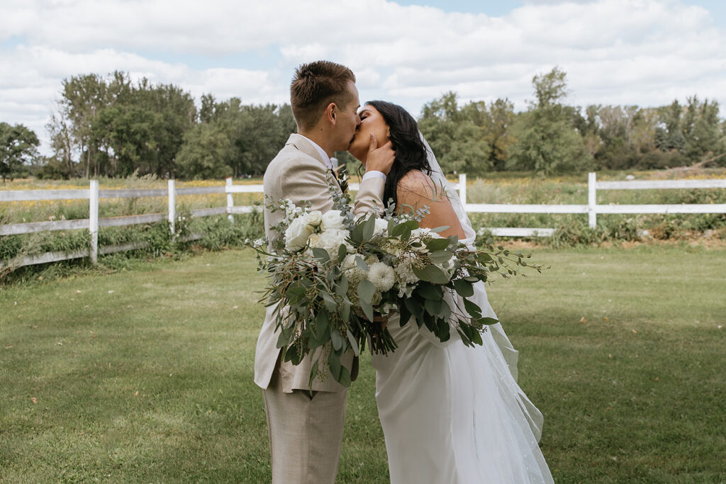 bride and groom kissing after their first look