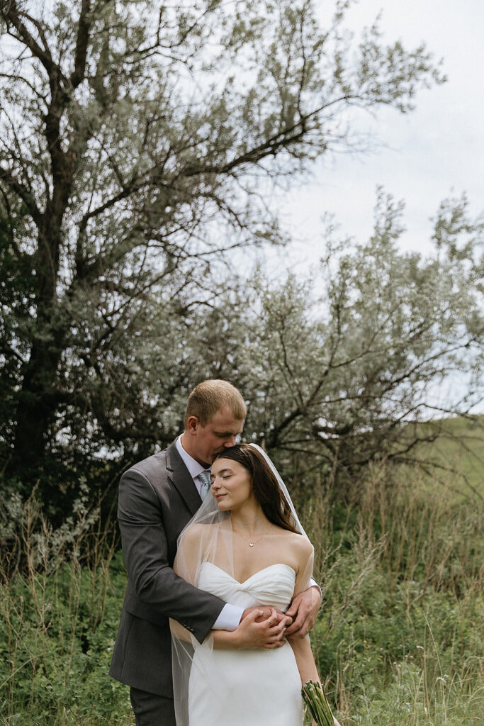 groom kissing the bride on the head
