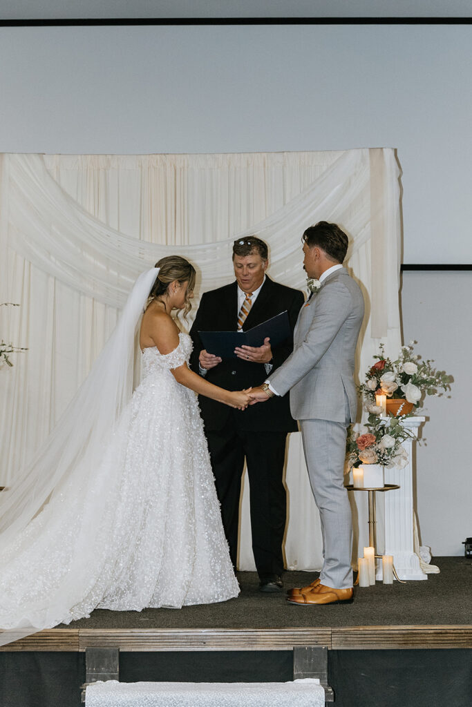 bride and groom holding hands during their ceremony