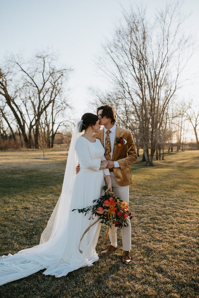 groom kissing the bride on the forehead 