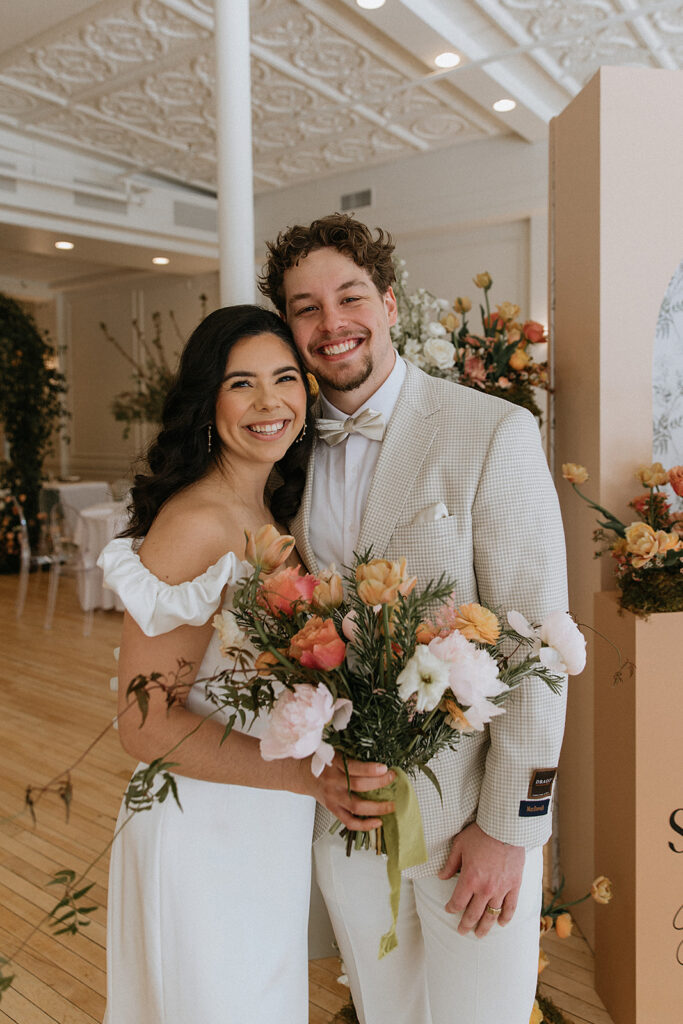 newlyweds smiling at the camera during their bridal photos 
